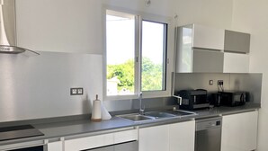 Eine moderne Küche mit Spüle aus Edelstahl, einem schwarzen Toaster und einem Geschirrspüler.