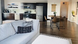 A modern kitchen with dark cabinets, a microwave, and a refrigerator. - Prime Rental Location for Super Bowl LV Experience (Tampa)