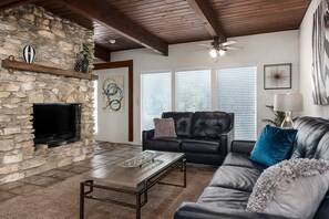 Cozy living room with a fireplace, flat-screen TV, and comfortable seating area.