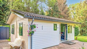 Une petite maison de plain-pied, dotée d’un toit en pente, d’un porche à l’avant et d’une porte donnant sur un vestibule abrité.