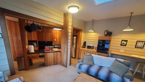 A compact living space with a kitchenette, a sofa, and a dining area. - Cozy Downtown Guesthouse (Silverton)