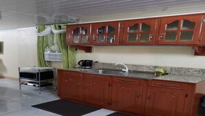 Een keuken met houten kastjes, een granieten aanrecht, een spoelbak en een fornuis.