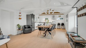 A modern kitchen with a central island, a dining area with a wooden table and chairs, and a living space with a sofa and a coffee table. - Pet friendly home in Grenaa with WiFi (Grenaa)