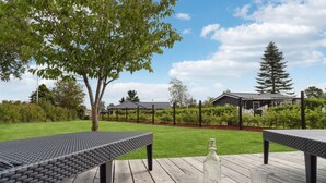 An outdoor patio area with two dark-colored tables and a bottle of water. - Pet friendly home in Grenaa with WiFi (Grenaa)