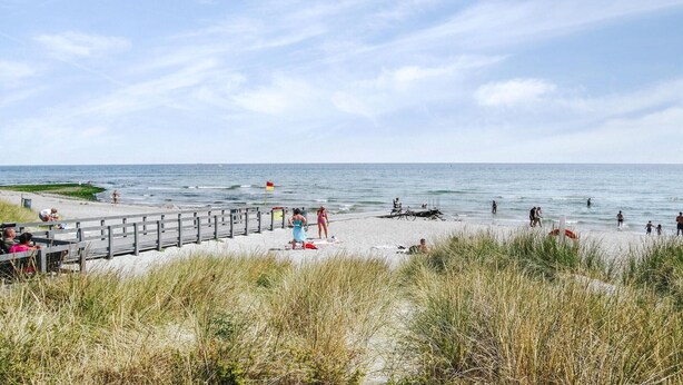 A beach with a wooden pier, people walking, and the ocean in the background. - Pet friendly home in Grenaa with WiFi (Grenaa)