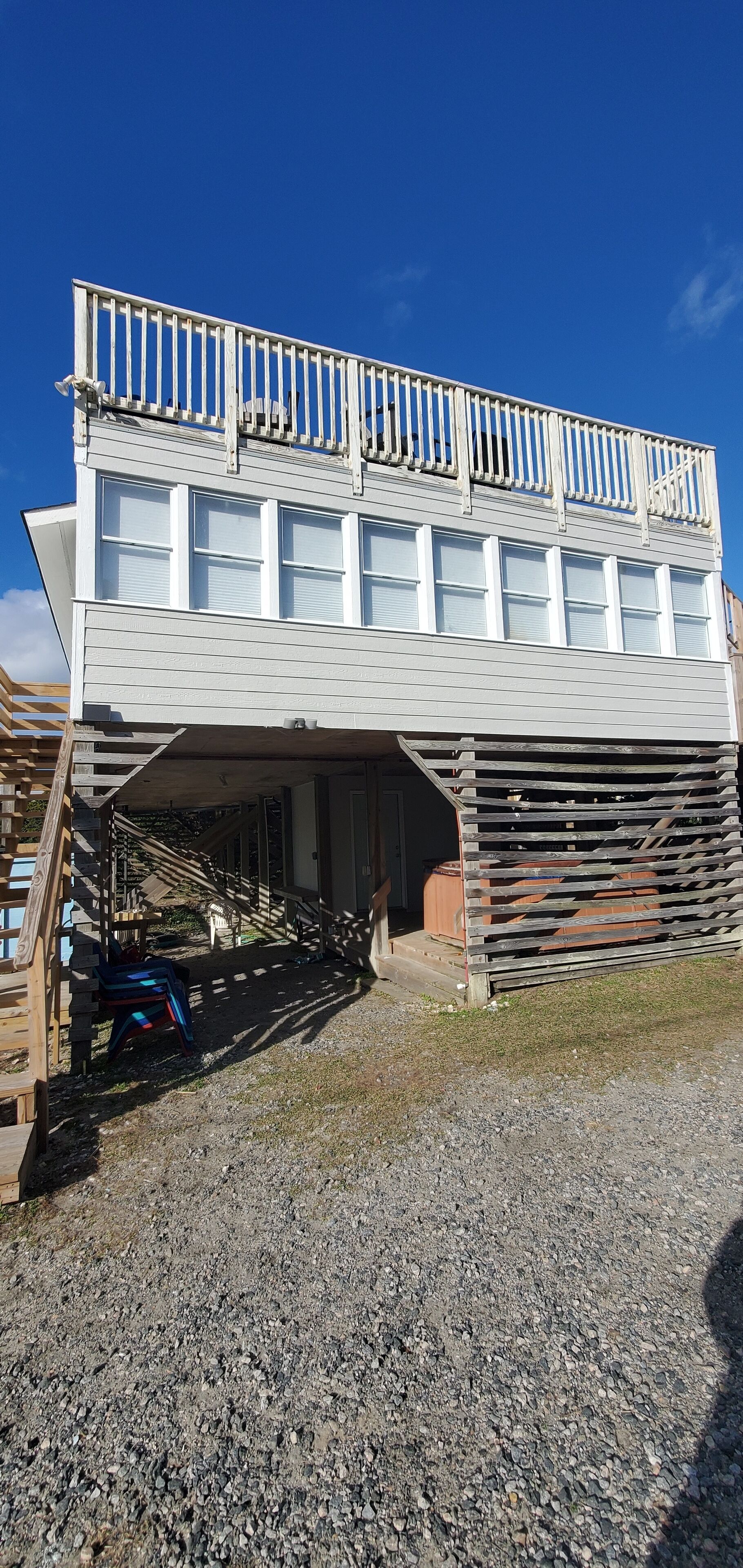 A two-story building with a balcony and a covered entrance.