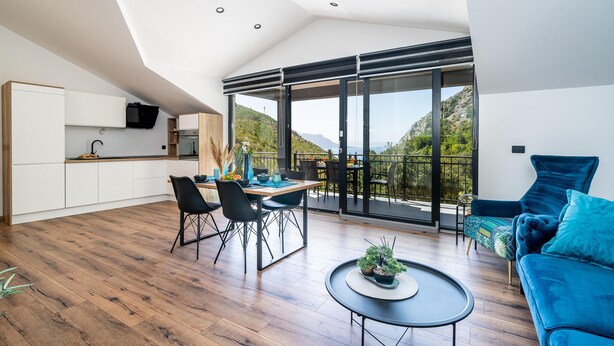 Une cuisine moderne avec des meubles blancs et un coin repas comprenant une table et des chaises.