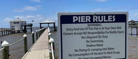 Un muelle con un cartel que enumera las normas y advertencias del muelle.