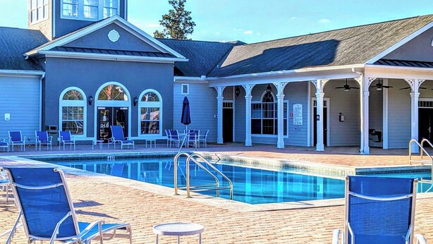 A pool area with lounge chairs and a covered seating area. - Homely spacious 2BD Close to Disney (Kissimmee)