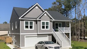 Une maison à deux étages avec un garage, une véranda et un escalier menant à l’étage supérieur.