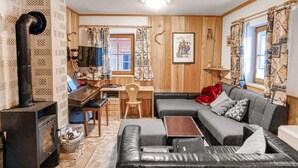 A cozy living room with a fireplace, a sofa, a coffee table, and a television.