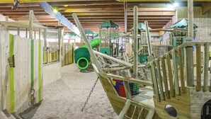 An indoor play area with various play structures, including a green slide and climbing frames. - 3 bedroom stunning home in Gramsbergen (Gramsbergen)