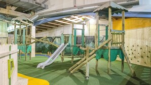 An indoor play area with climbing structures, slides, and artificial grass flooring. - 3 bedroom stunning home in Gramsbergen (Gramsbergen)
