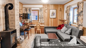 A cozy living room with a fireplace, a sofa, a coffee table, and a television. - Ferienhaus mit Bergpanorama (Ebensee)