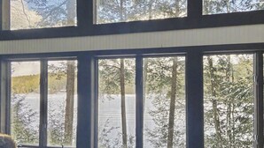 A room with large windows offering a view of a snowy landscape and trees. - Private Lake Front Adirondack Retreat on Loon Lake-20 Min from Lake George, Gore (Chestertown)