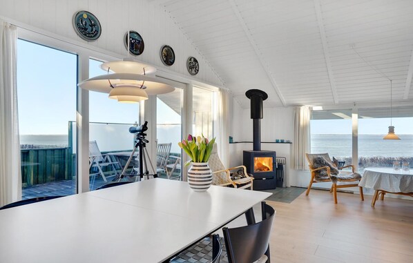 A spacious room with a large table, chairs, a telescope, and a wood-burning stove. - Gorgeous home in Esbjerg V (Esbjerg V)