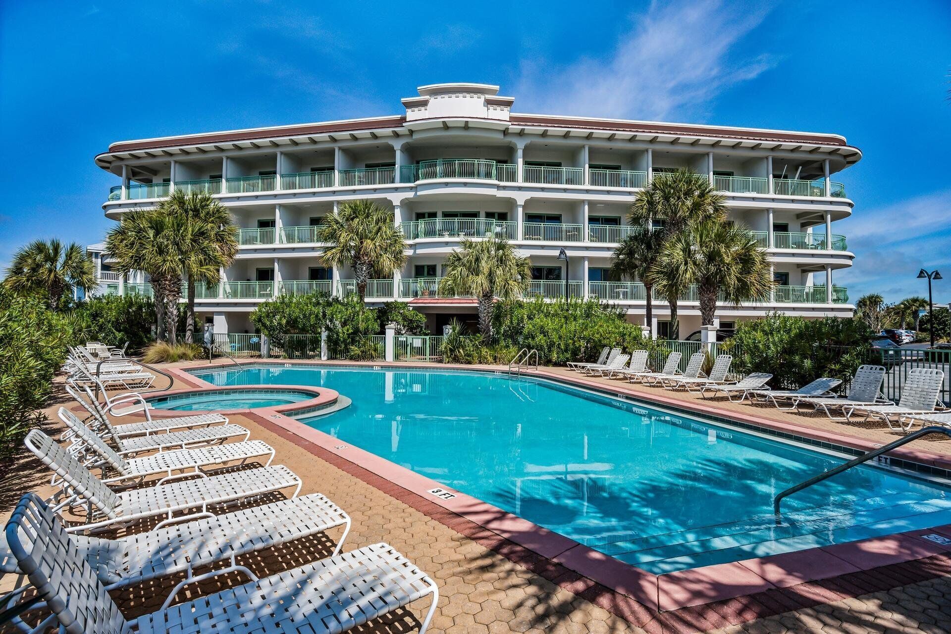 Ein Hotel mit großem Pool, mehreren Balkonen und Palmen.