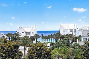 Ein Küstenhotel mit weißen Gebäuden, Palmen und Blick aufs Meer.