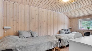 A small, cozy room with two beds, wooden walls, a window with a view, and a small desk. - Cozy home in ålbæk with kitchen (Ålbæk)