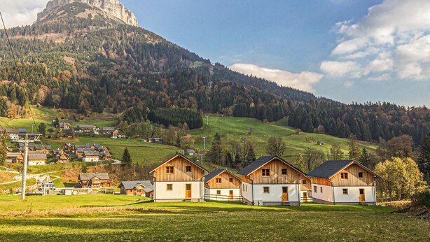 Un gruppo di baite in legno con le montagne sullo sfondo.
