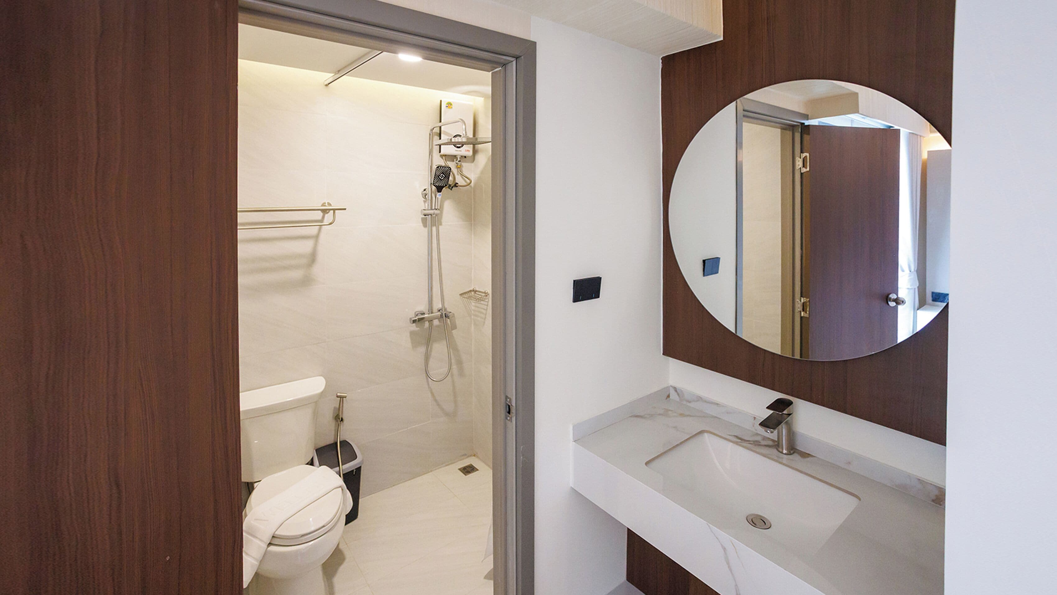 A modern bathroom with a toilet, shower, and sink.