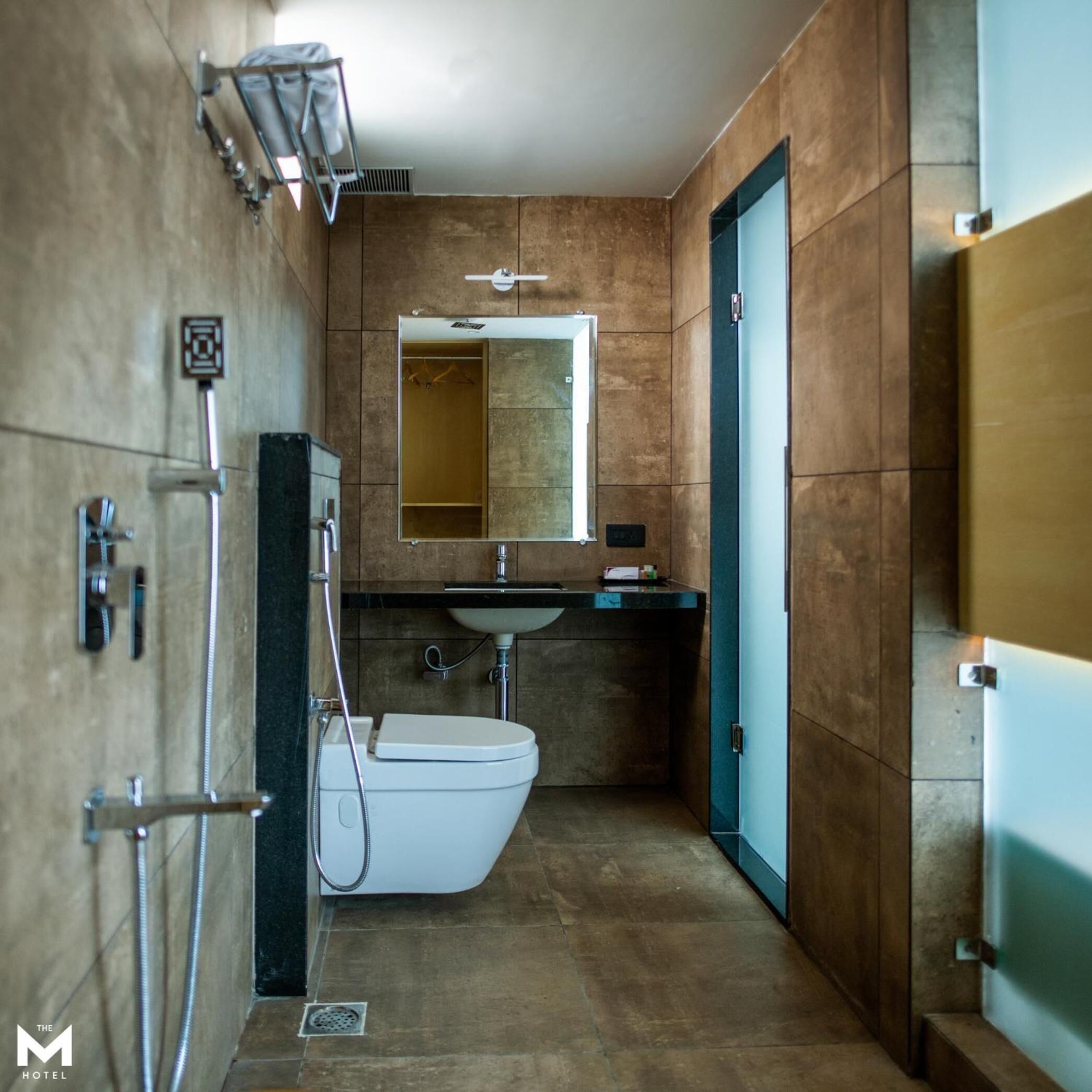 Et moderne badeværelse med toilet, vask og spejl.