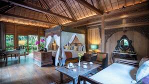 A spacious room with a large bed, a wooden ceiling, and a view of greenery outside. - Villa Kapungkur (Jimbaran)