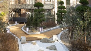 A modern building with a courtyard featuring rocks and a pathway. - Tomonoya Hotel & Ryokan Gyeongju (Gyeongju)