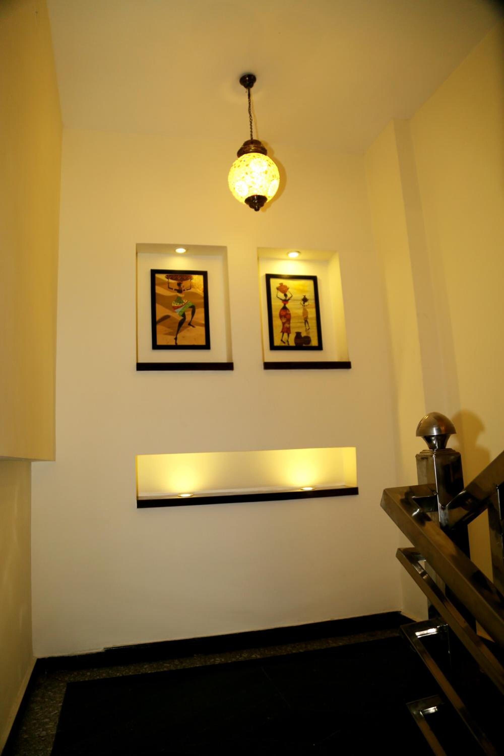 A staircase with a black handrail and a light fixture above.