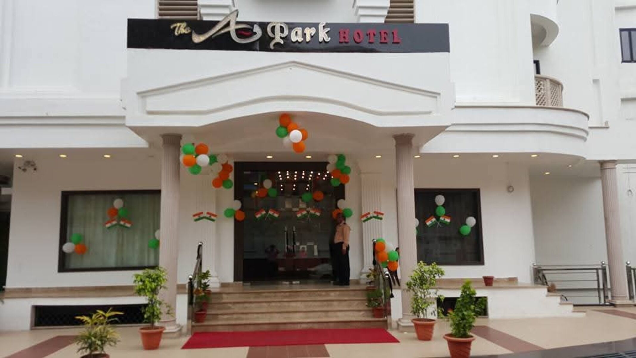 The Park Hotel with a grand entrance, a red carpet, and potted plants.