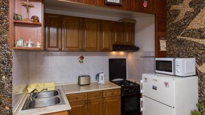 A kitchen with wooden cabinets, a stove, a microwave, and a sink. - Apartment Horizont (Dubrovnik)