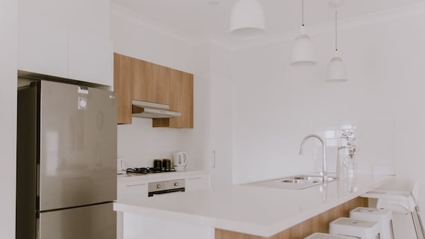 A modern kitchen with white cabinetry, a stainless steel refrigerator, a gas stove, and a sink with a faucet. - Quiet relaxing Location,2 Bedroom 2 Bathroom Guesthouse.Walking distance to CBD. (Mudgee)