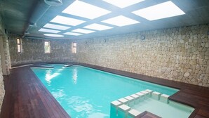 Ein Innenpool mit Steinwänden und Holzboden.