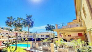Ein Resort mit mehreren Gebäuden, einem Schwimmbad und Palmen.