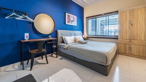 A bedroom with a bed, a desk, a chair, a wardrobe, and a window with blinds. - Conceptual Homestay 3BR 9PAX (Ampang)