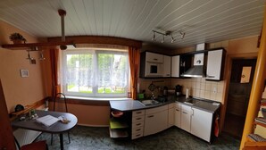 Una cucina compatta con finestra, lavello, piano cottura e pensili.
