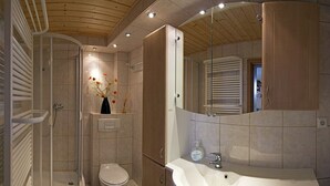 Un bagno moderno con doccia, WC e lavandino.