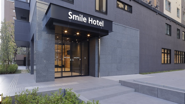 A modern building with a sign reading "Smile Hotel".