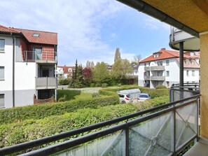 Ein Wohngebiet mit modernen Gebäuden, einem sichtbaren Auto und einem gepflegten Garten.