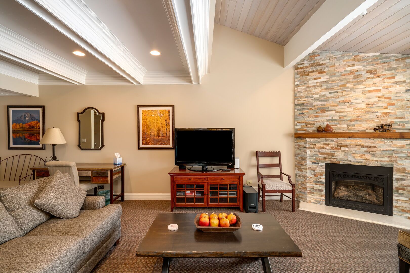 A living room with a fireplace, a television, and a sofa.