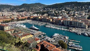 A coastal cityscape with a marina, buildings, and hills in the background. - Spacious apartment in the centre of the old town near cafes, beach, and more (Nice)