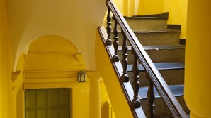 A staircase with a wooden handrail and yellow walls. - Spacious apartment in the centre of the old town near cafes, beach, and more (Nice)