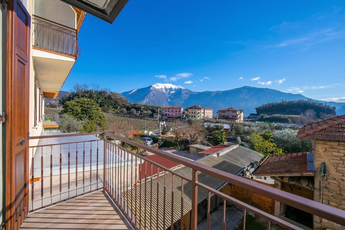 Ein Balkon mit Blick auf einen Berg und umliegende Gebäude.