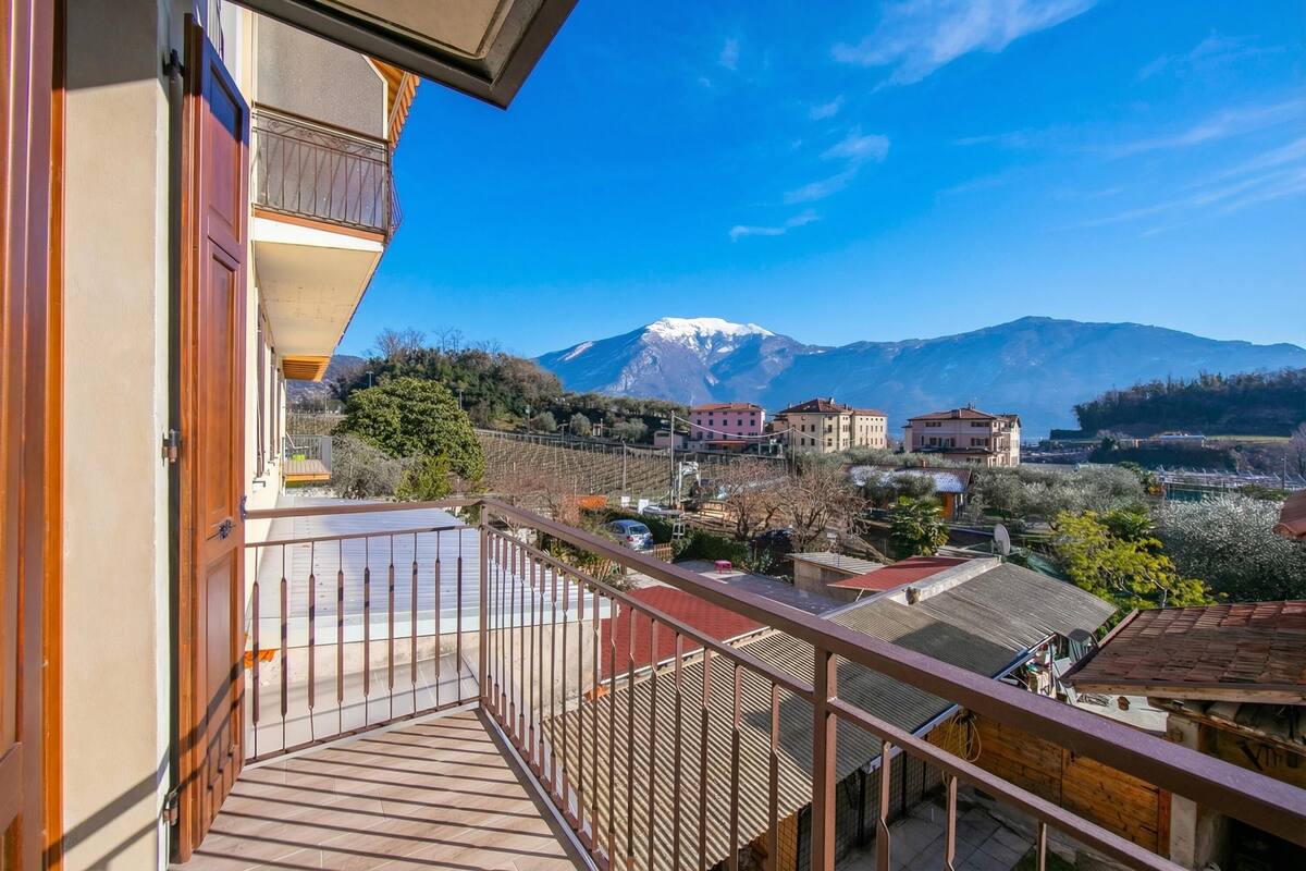 Ein Balkon mit Blick auf einen Berg, Gebäude und Bäume.