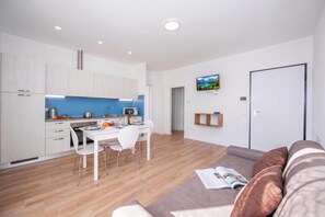 A modern apartment with a kitchen, dining area, and living room. - Residenza Giada (Riva del Garda)