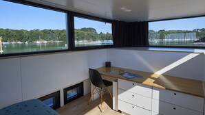 Une chambre moderne dotée d’une grande fenêtre, d’un bureau et d’une chaise.