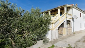 A two-story building with a balcony and a staircase leading to the upper floor. - Apartment Masholina (Tribunj)