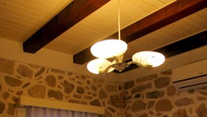 A dining area with a stone wall, a white table, and chairs. - Apartments Cukarin (Bol)