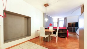 A modern living room with a dining area, a TV, and a large window. - "Lauben Uno" New apartment with modern design, in the center of Merano! (Merano)