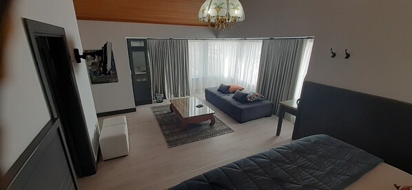 A modern living room with a sofa, coffee table, and a patterned rug.